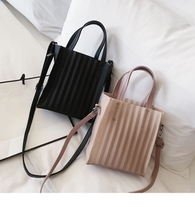 Détail de la texture plissée sur des sacs cabas en cuir noir et rose avec bandoulière