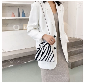 Fashionable zebra print faux fur handbag styled with a white blazer and grey knit dress