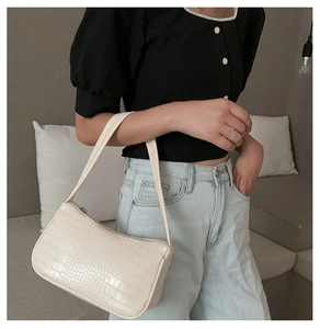 Gros plan du sac baguette blanc crème avec texture crocodile sur une épaule