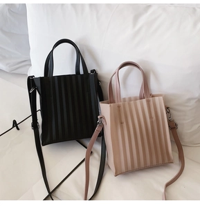 Gros plan de mini sacs cabas plissés en noir et beige avec des bandoulières réglables