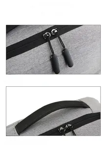 Detail view of gray backpack featuring reinforced top handle and dual smooth metal zippers