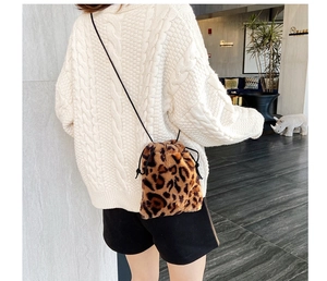 Detail view of leopard print faux fur bucket bag with drawstring closure on model back