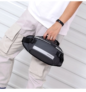 Detail of grey nylon sports waist bag featuring reflective safety strip and printed strap
