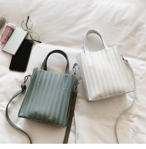 Détails des mini sacs cabas plissés en vert sauge et blanc avec bandoulières fines