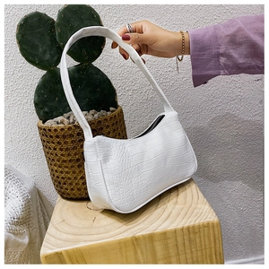 Vue détaillée du sac baguette blanc avec texture crocodile et fermeture éclair élégante