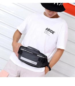 Detail of dark grey waterproof waist bag with silver reflective strip and brand logo