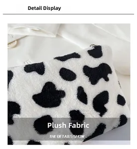 Gros plan sur la texture en peluche et le zip métallique du porte-monnaie vache