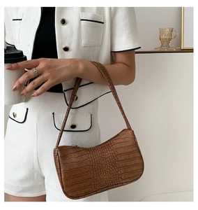 Détail du sac à main marron à motif crocodile avec fermeture éclair élégante