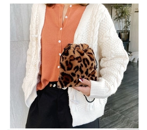 Close-up of leopard print faux fur bucket bag styled with a white knit cardigan