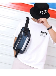 Detail view of navy blue sports fanny pack with reflective strips and adjustable strap