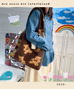 Borsa tote in pile marrone scuro con motivo a orsetti indossata da modella in ambiente domestico