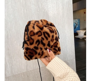 Detail view of leopard print faux fur bucket bag with a black drawstring closure