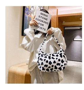Borsa hobo in peluche con stampa mucca indossata da modella in un interno moderno