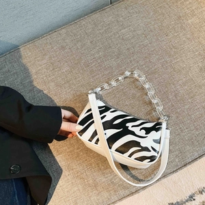 Fashionable zebra print baguette shoulder bag with white leather and acrylic chain