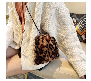 Close-up of leopard print faux fur bucket bag with drawstring in a warm home setting