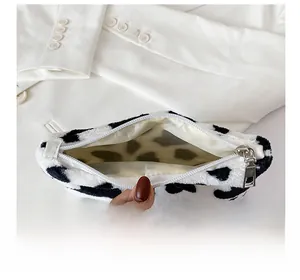 Détail du porte-monnaie en peluche à motif vache avec doublure beige et fermeture éclair