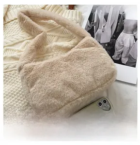 Plush shoulder bag in beige faux fur shown next to a smartphone for size comparison