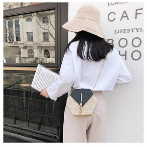 Chic hexagonal straw crossbody bag with black leather flap and stylish tassel detail