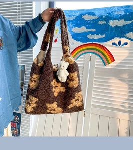Dettaglio di una borsa tote in pile marrone con stampa orsetto e ciondolo orsetto