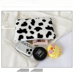 Vue détaillée de la pochette peluche motif vache montrant la capacité pour cosmétiques