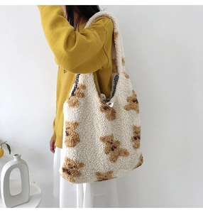 Detailed view of plush teddy fleece tote bag with bear patterns and blue checkered lining