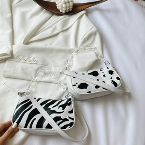 Minimalist baguette bags with cow and zebra patterns featuring acrylic chain straps