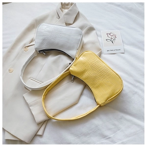 Détail des sacs baguette blancs et jaunes à motif crocodile avec fermetures éclair en métal