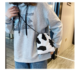 Detailed view of the cow print plush texture on this stylish drawstring bucket bag