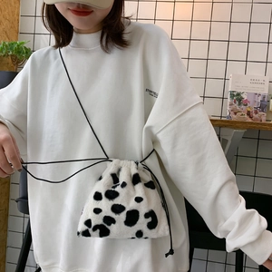 Chic cow print faux fur drawstring bucket bag with minimalist black crossbody strap