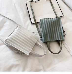 Détail de sacs cabas carrés plissés en blanc et vert sauge avec bandoulière amovible