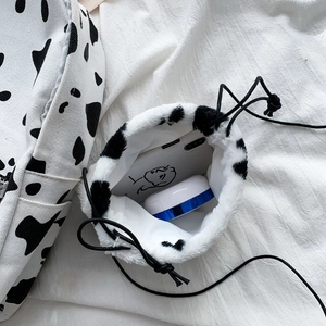 Winter plush drawstring bag with cow print pattern and soft faux fur texture for women
