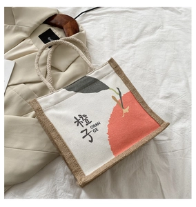 Detail of the thick woven cotton rope handle and premium orange print on canvas tote