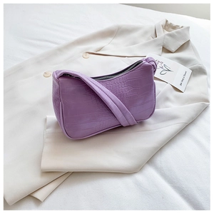 Détail du sac baguette violet en similicuir avec une texture crocodile gaufrée élégante