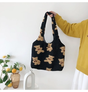 Detail of black teddy plush tote bag with yellow bear patterns and plaid lining