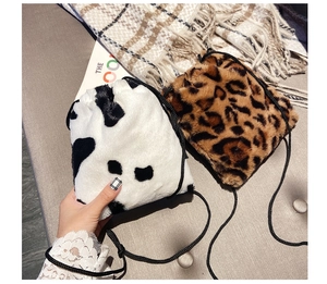 Close-up of plush drawstring bucket bag featuring faux fur leopard and cow print texture