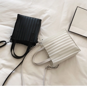 Vue détaillée des sacs cabas plissés noir et blanc avec texture verticale et bandoulières