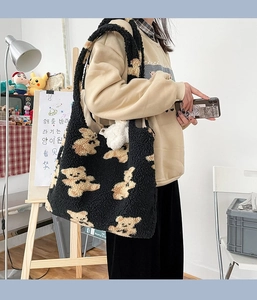 Dettaglio della borsa tote in pile nero con motivo orso e portachiavi in peluche