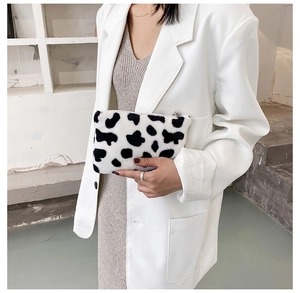 Mini pochette en peluche imprimé vache portée avec une tenue de bureau chic