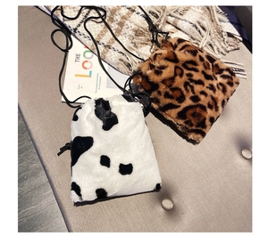 Detail of plush faux fur bucket bags in cow and leopard prints with drawstring straps