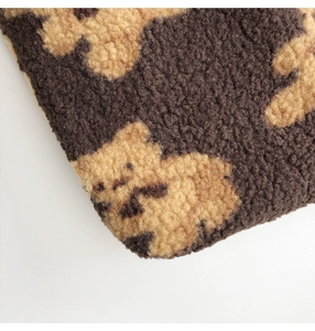 Close-up of soft plush teddy bear pattern fabric with brown and beige texture
