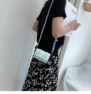 Detail of mint green mini crossbody bag with square buckles and stylish blue chain strap