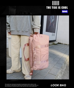 Détail du sac de voyage rose montrant la texture en nylon et la poche latérale zippée