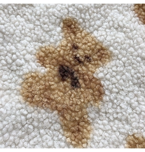 Close-up of the plush texture and cute brown bear pattern on a large fleece shopping bag