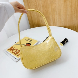 Sac à épaule baguette jaune à motif crocodile avec un design minimaliste et incurvé