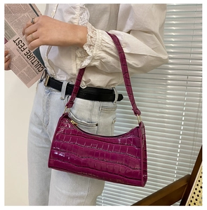Vista detallada del bolso de hombro en charol morado con textura de piel de cocodrilo