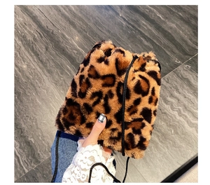 Detail of plush leopard print bucket bag featuring a drawstring closure and slim strap