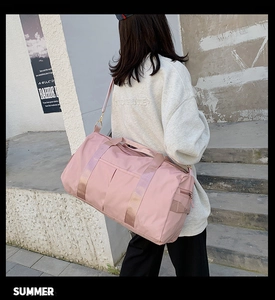 Photo de mode d'un grand sac de voyage rose en nylon imperméable porté par un mannequin