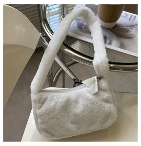 Detailed close-up of a white plush faux fur shoulder bag featuring a sweet fabric bow