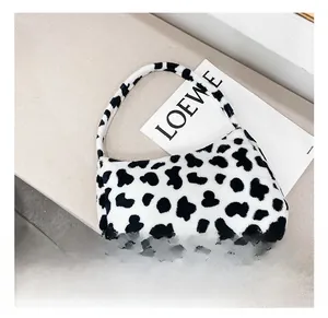 Dettaglio della borsa a tracolla in peluche con un elegante motivo muccato bianco e nero