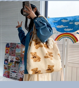 Dettaglio della borsa tote color crema con stampa orsetto e ciondolo in peluche morbido